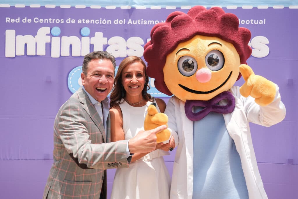 Pablo Lemus Navarro y una mujer sonriente posan junto a un personaje de caricatura en el lanzamiento de un centro de autismo en Tepatitlán.