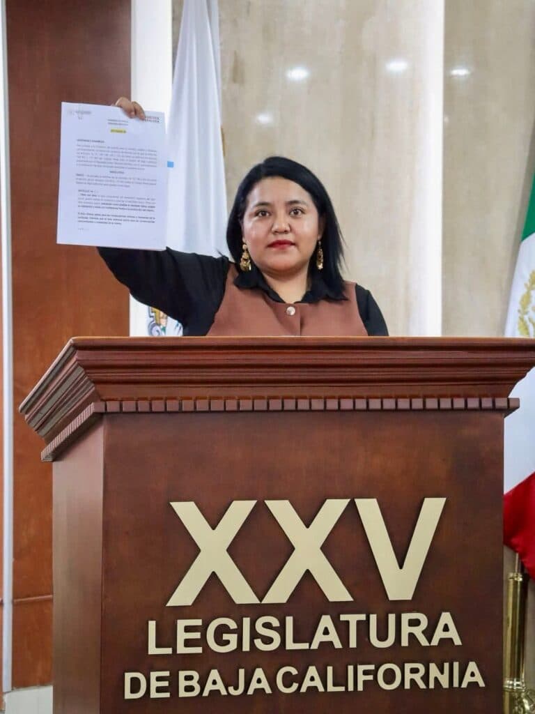 Evelyn Sánchez sostiene un documento frente al estrado de la XXV Legislatura de Baja California, destacando su reforma al Código Penal.