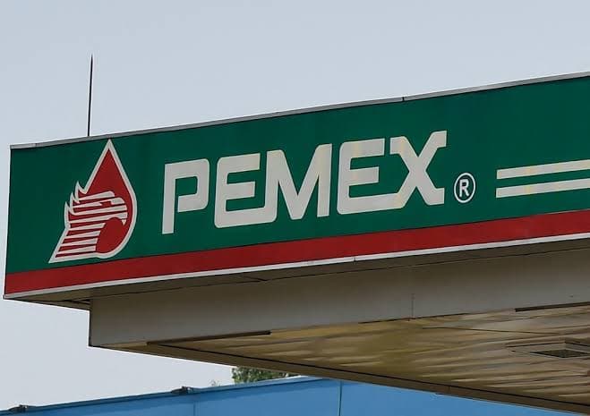 Logo de Pemex en una estación de servicio, resaltando la marca de la empresa estatal en el contexto de su calificación crediticia.