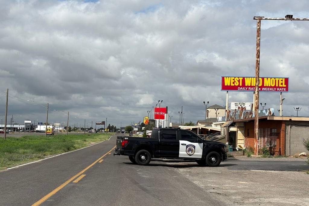 Camioneta de policía bloqueando la carretera cerca del West Wind Motel en Midland, Texas, tras el tiroteo que dejó un muerto y varios heridos.