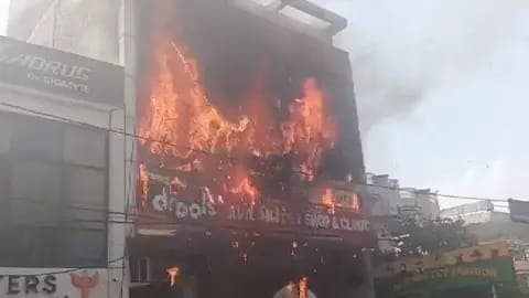 Incendio devastador en un edificio de tres niveles en Lucknow, India, con llamas intensas y humo visible, tras la tragedia en una escuela.