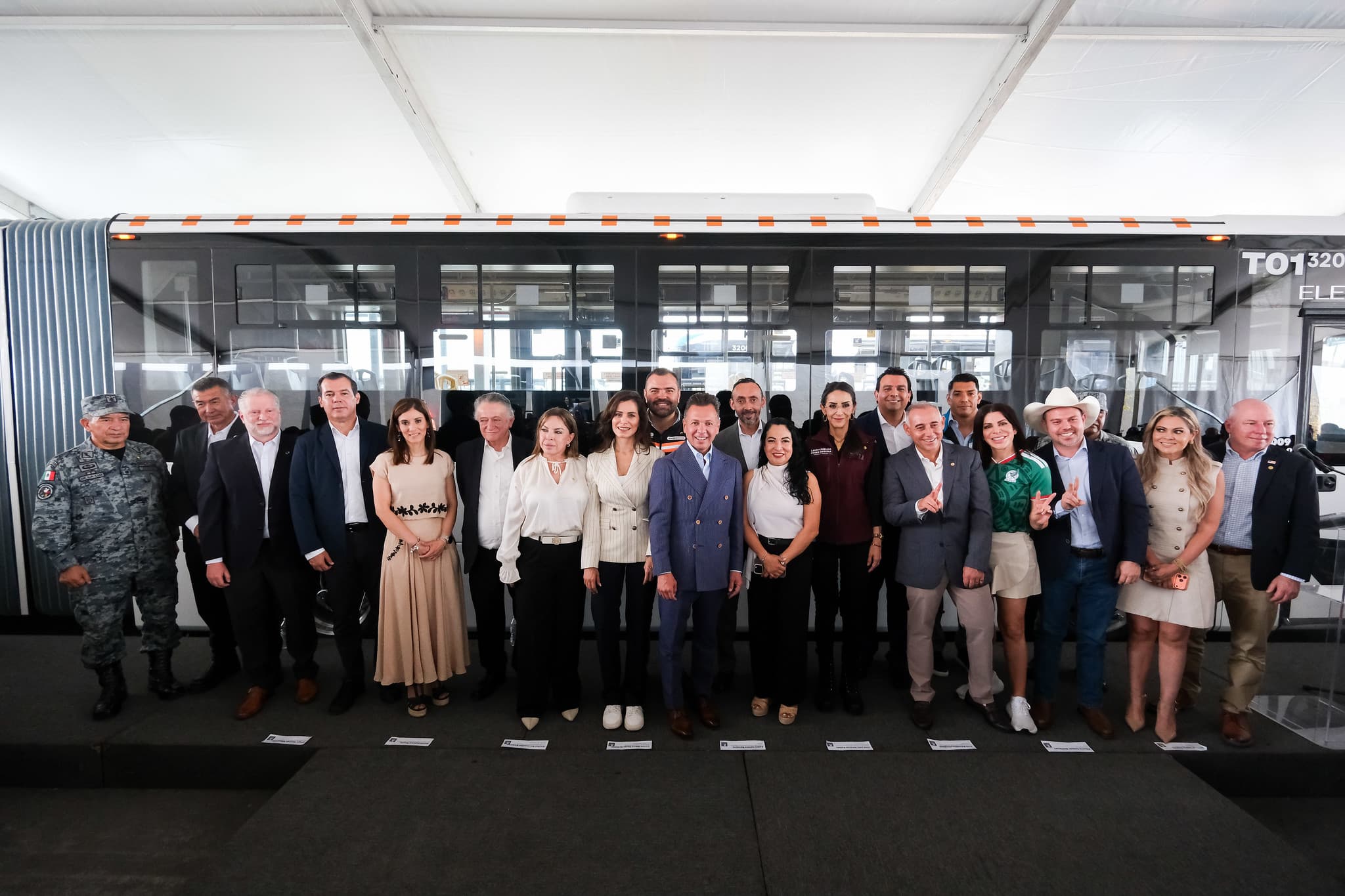 Inauguración de la Línea 5 Macro Aeropuerto en Jalisco, con autoridades y representantes del transporte público junto a un autobús eléctrico.