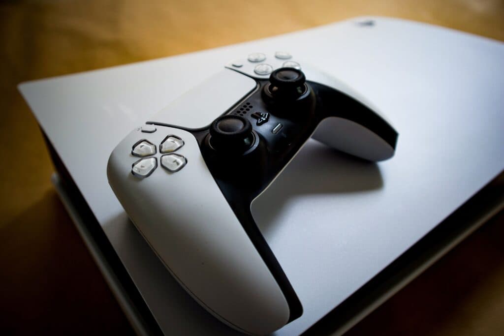 Controlador de PlayStation 5 sobre la consola, simbolizando el cambio hacia el futuro digital de los videojuegos.