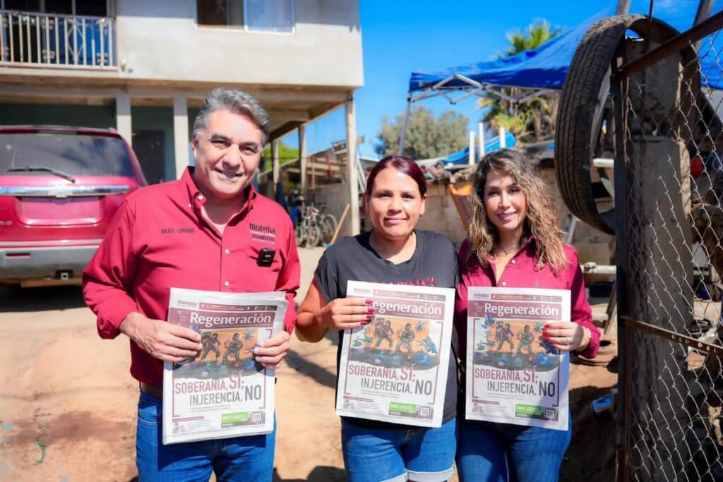 Jesús Ruiz Uribe y su esposa Marcela Valdez entregan el órgano de difusión "Regeneración" a una residente en Ensenada.