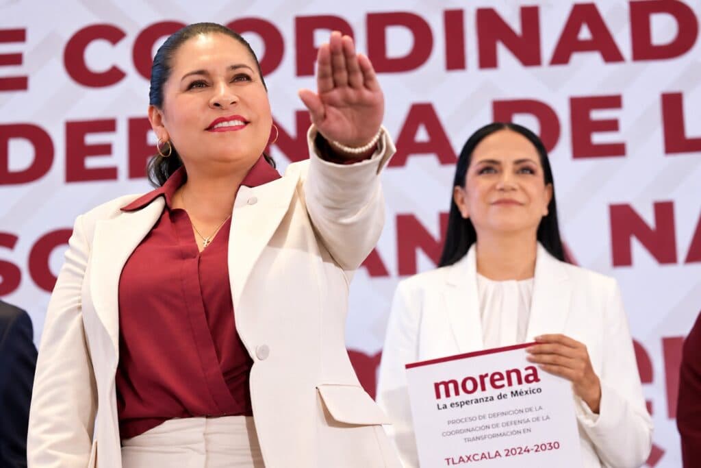 Ana Lilia Rivera, nueva Coordinadora de Defensa de MORENA en Tlaxcala, gesticula durante su presentación, acompañada por otra mujer.