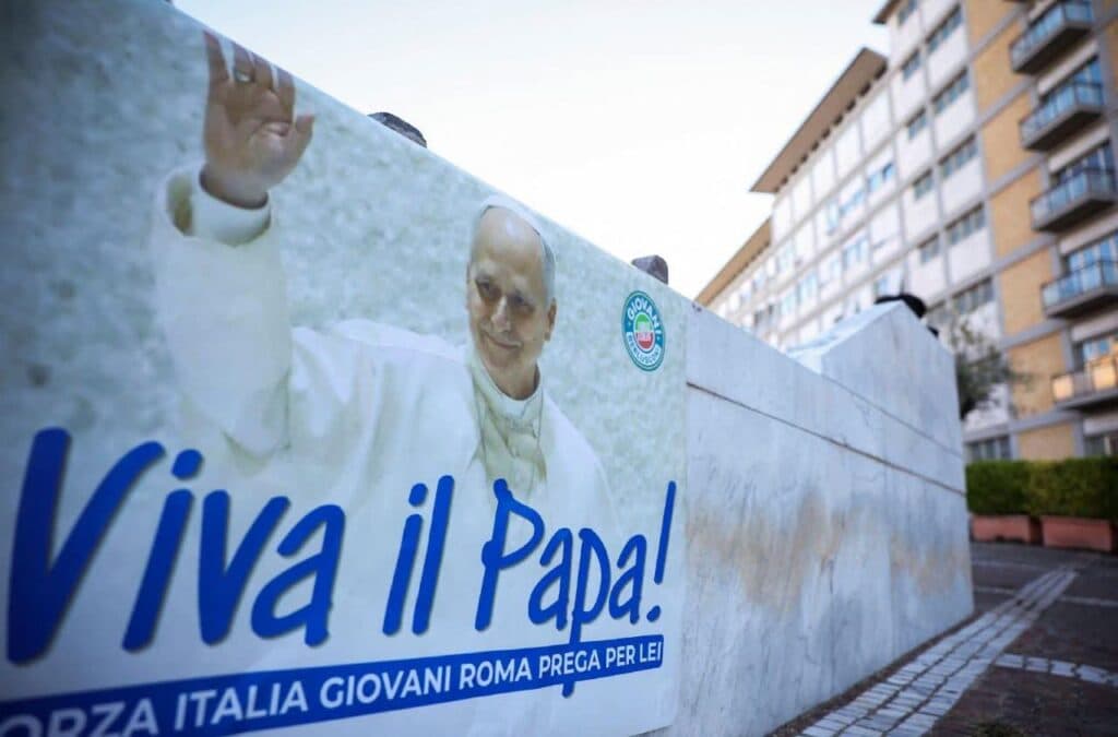 Cartel en apoyo al papa León XIV con la frase "Viva il Papa!" en un entorno urbano, reflejando el interés por su salud tras la cirugía.