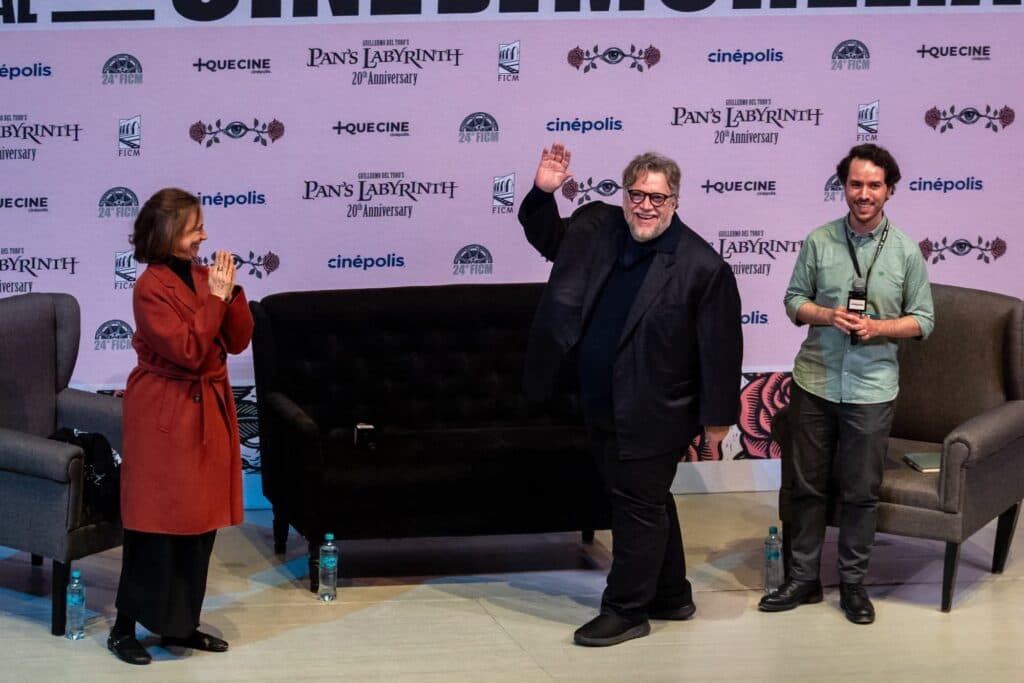 Guillermo del Toro saluda al público en el Festival Internacional de Cine de Morelia, junto a estudiantes que denuncian agua