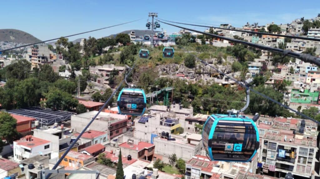Vista aérea del Cablebús Línea 5 en Álvaro Obregón, mostrando las cabinas sobre las casas y el paisaje urbano.